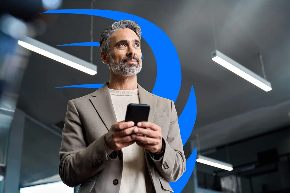 Homem grisalho, com celular na mão olhando para o futuro